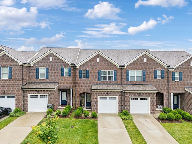 townhome / multi-family property with a garage and a front yard