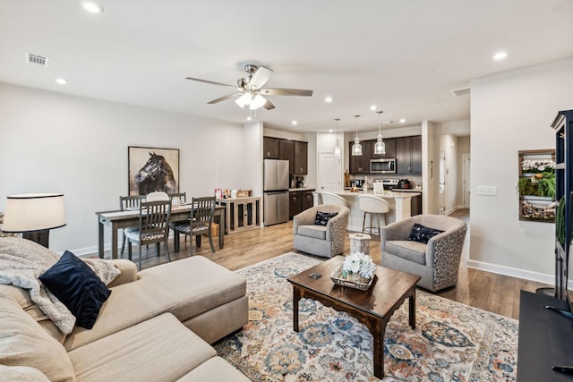 living room featuring hardwood / wood-style floors and ceiling fan