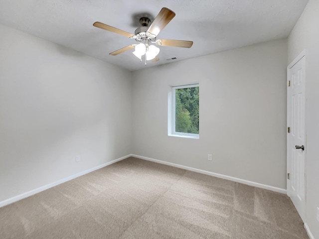 unfurnished room featuring carpet floors, baseboards, visible vents, and ceiling fan