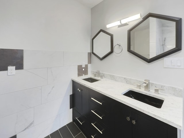 full bath featuring a sink, tile walls, and double vanity