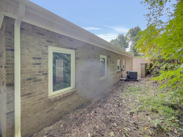 view of home's exterior featuring central AC and brick siding