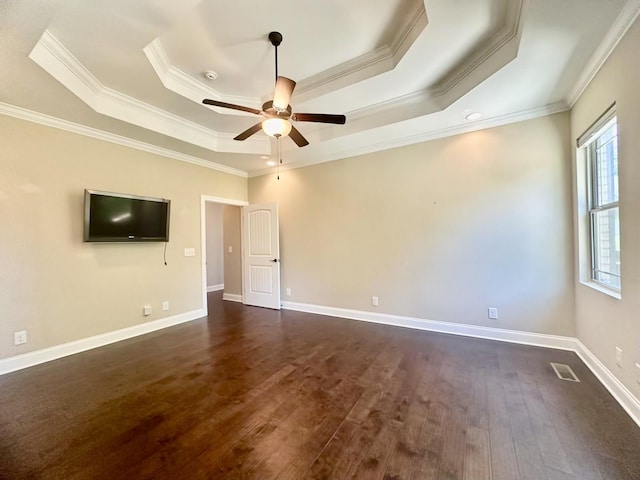 interior space with a tray ceiling, dark hardwood / wood-style floors, ornamental molding, and ceiling fan