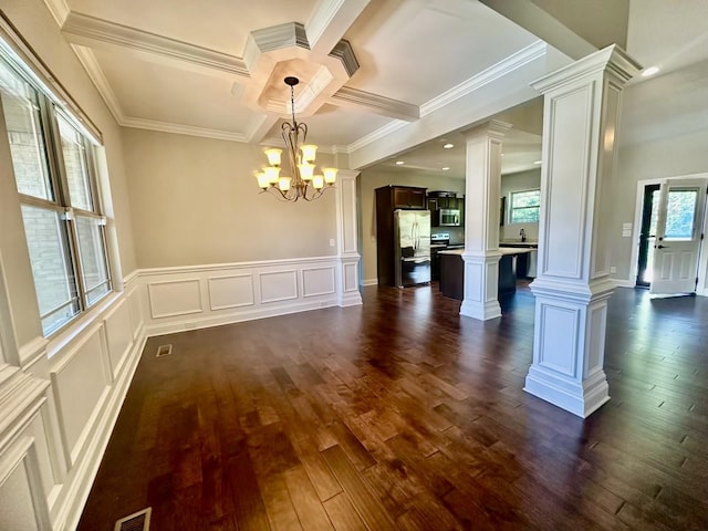 unfurnished dining area featuring decorative columns, ornamental molding, coffered ceiling, an inviting chandelier, and beamed ceiling