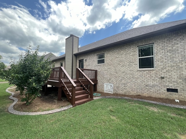 back of property with a lawn and a deck