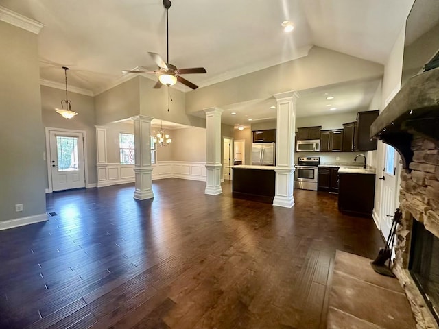 unfurnished living room featuring ceiling fan with notable chandelier, sink, a fireplace, dark hardwood / wood-style floors, and lofted ceiling