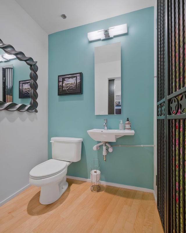 bathroom featuring sink, hardwood / wood-style flooring, and toilet