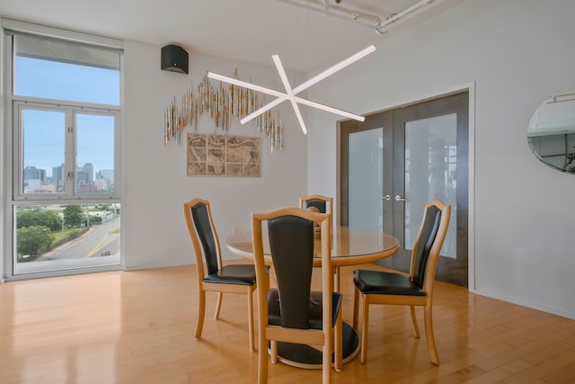 dining room with light wood-type flooring and french doors