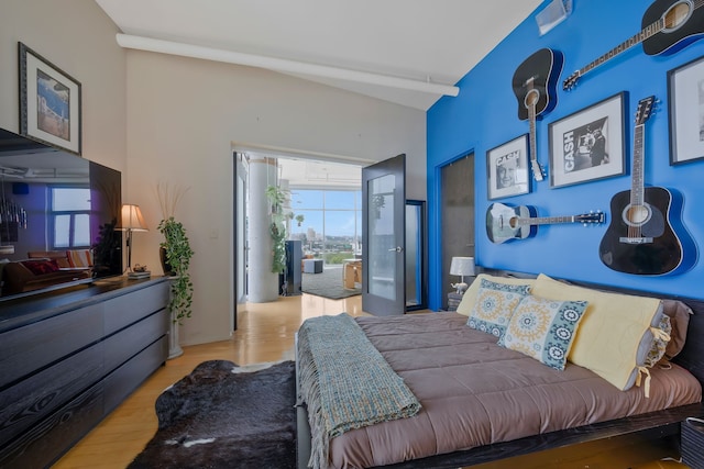 bedroom with vaulted ceiling and light wood-type flooring