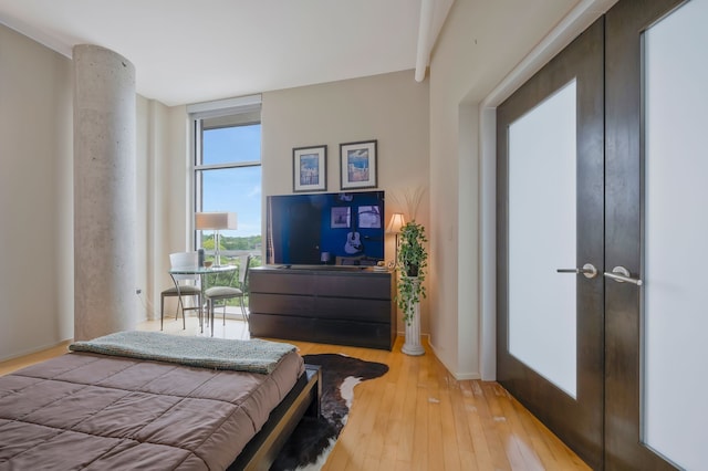 bedroom with french doors and light hardwood / wood-style flooring