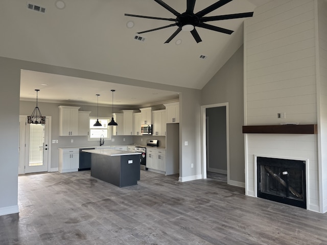 kitchen featuring white cabinetry, a center island, pendant lighting, and appliances with stainless steel finishes