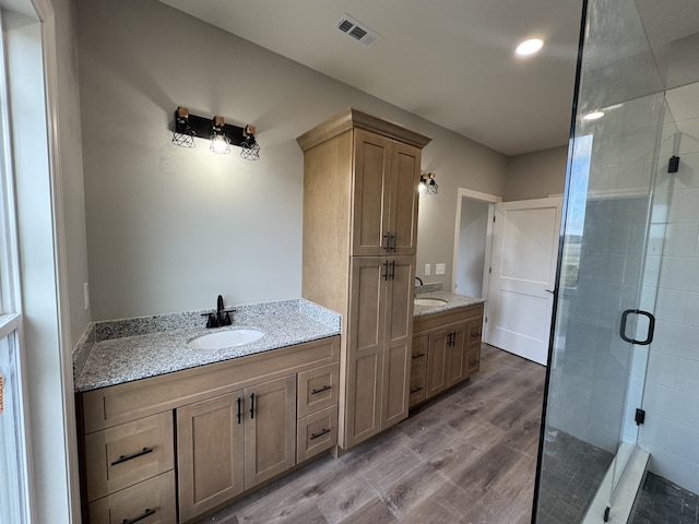 bathroom featuring vanity, hardwood / wood-style flooring, and a shower with door