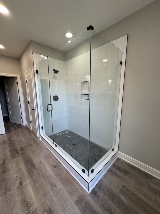 bathroom featuring hardwood / wood-style flooring and a shower with shower door