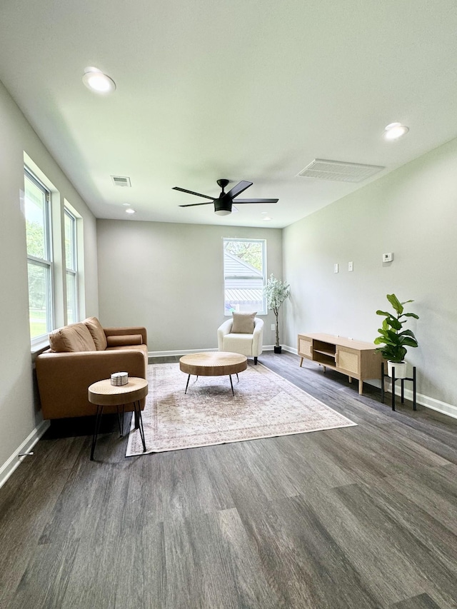 living room with dark hardwood / wood-style flooring, a wealth of natural light, and ceiling fan