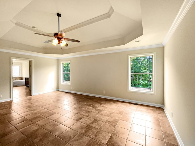 tiled spare room featuring ceiling fan, a raised ceiling, and crown molding