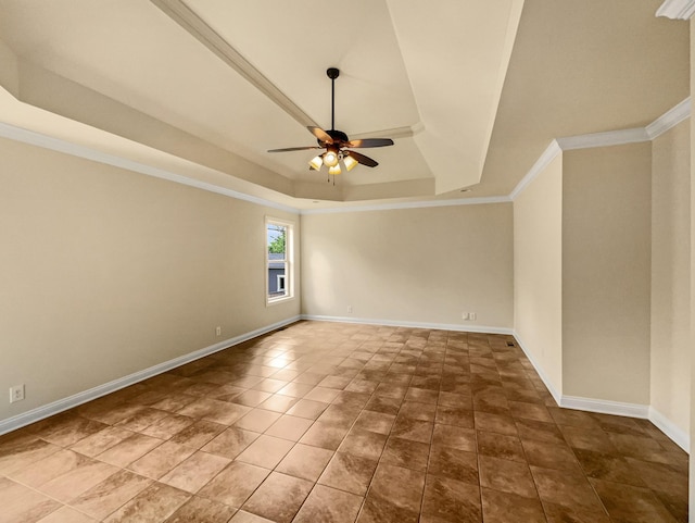 tiled empty room with a tray ceiling, ceiling fan, and ornamental molding