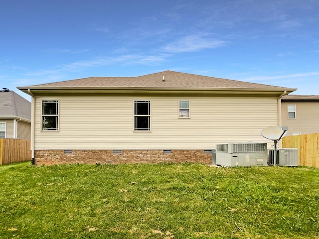 rear view of property featuring a yard and central AC