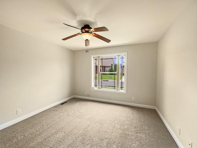 spare room featuring ceiling fan and carpet