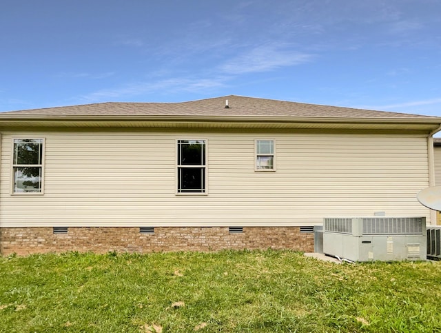 view of side of home with a lawn and cooling unit