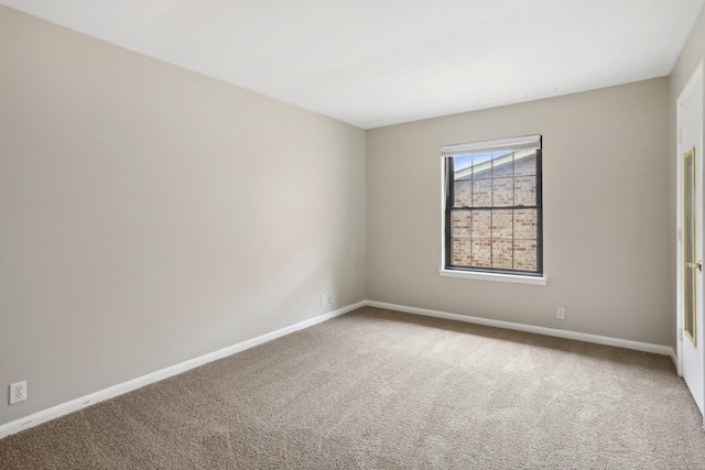 carpeted spare room featuring baseboards