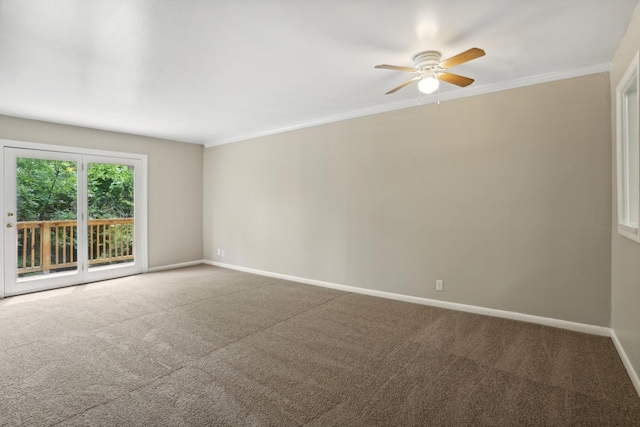 spare room with ornamental molding, carpet flooring, baseboards, and a ceiling fan