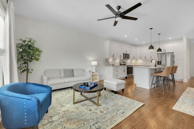 living room with ceiling fan and light hardwood / wood-style flooring