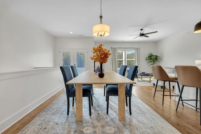 dining room featuring ceiling fan, light hardwood / wood-style floors, and french doors