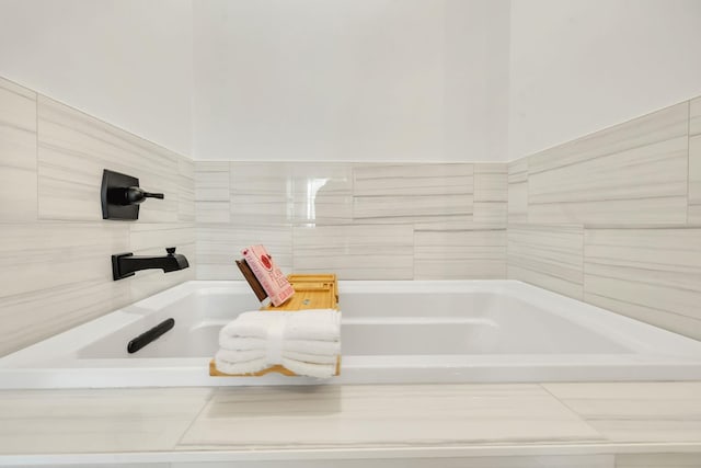 bathroom with a relaxing tiled tub