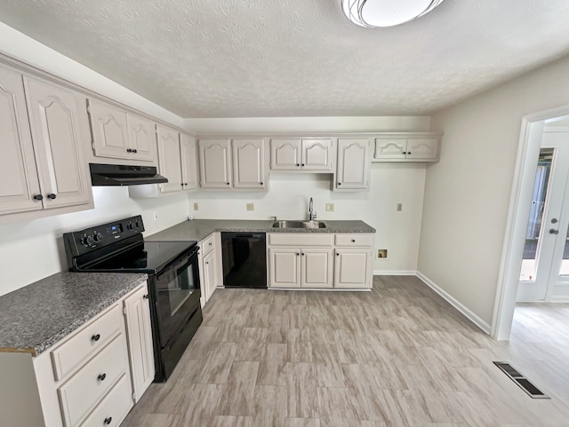 kitchen with black appliances, white cabinetry, light wood-type flooring, a textured ceiling, and sink