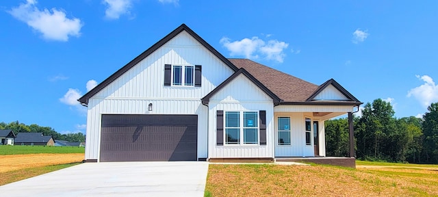 modern inspired farmhouse with a front yard and a garage