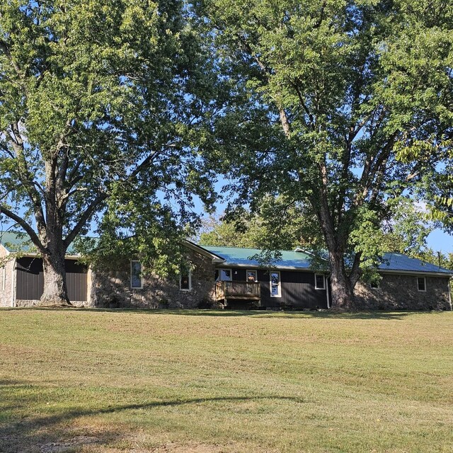 view of front of home with a wooden deck and a front lawn