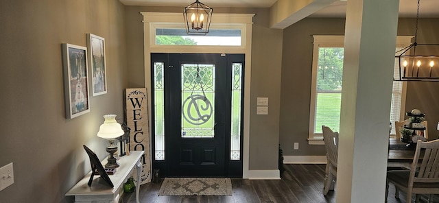 foyer entrance with a chandelier and dark hardwood / wood-style floors