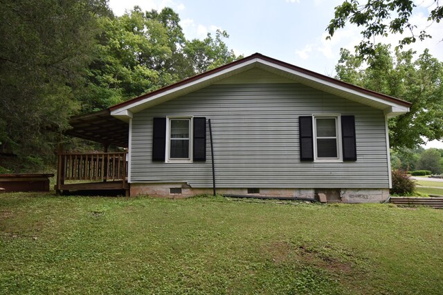 view of side of property featuring a wooden deck and a yard