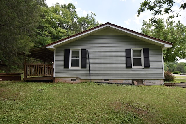 view of side of property with a wooden deck and a lawn