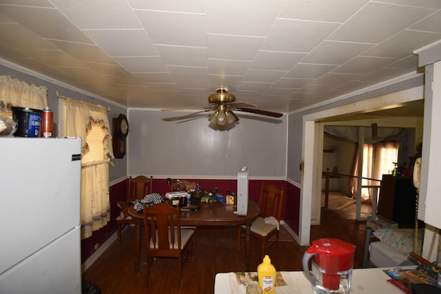 dining room with dark wood-type flooring, ceiling fan, and crown molding