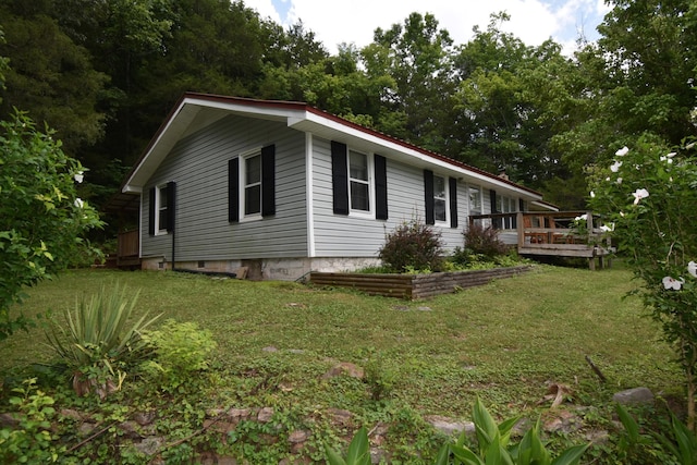 view of side of property featuring a yard and a deck