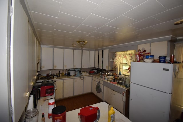 kitchen featuring white cabinetry, sink, dark hardwood / wood-style floors, and white fridge