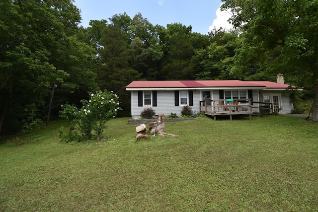 rear view of house featuring a wooden deck and a lawn