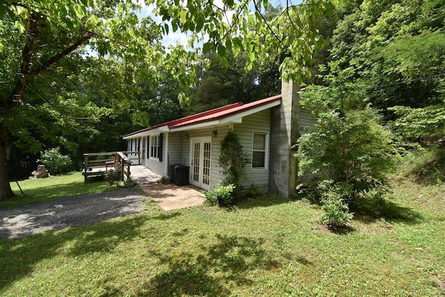 view of home's exterior with french doors and a yard