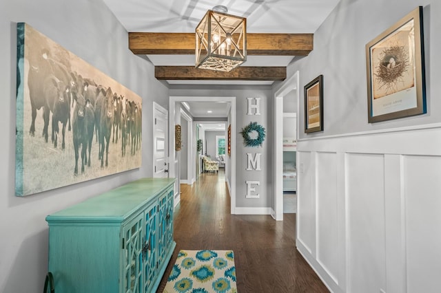 hallway featuring beam ceiling, a chandelier, and dark wood-type flooring