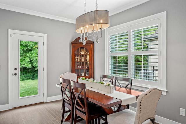 dining area with light hardwood / wood-style flooring, plenty of natural light, and crown molding