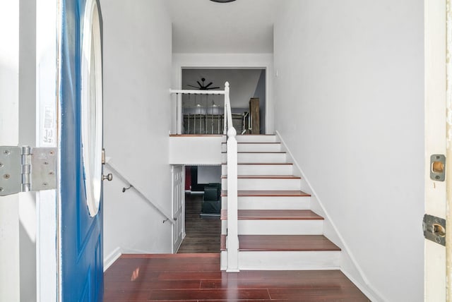 staircase with hardwood / wood-style floors and ceiling fan