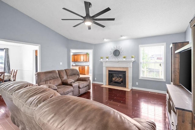 living room featuring ceiling fan, dark hardwood / wood-style flooring, and vaulted ceiling