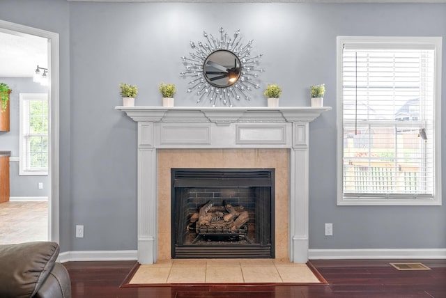 room details featuring a tiled fireplace and hardwood / wood-style floors