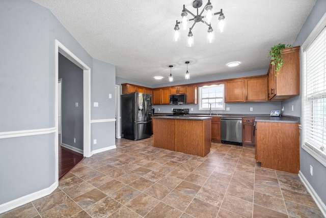 kitchen with stainless steel appliances, a kitchen island, a textured ceiling, and sink