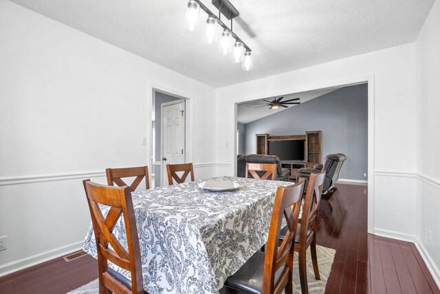 dining room with lofted ceiling, a textured ceiling, ceiling fan, and dark wood-type flooring