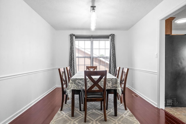 dining area with a textured ceiling and hardwood / wood-style flooring