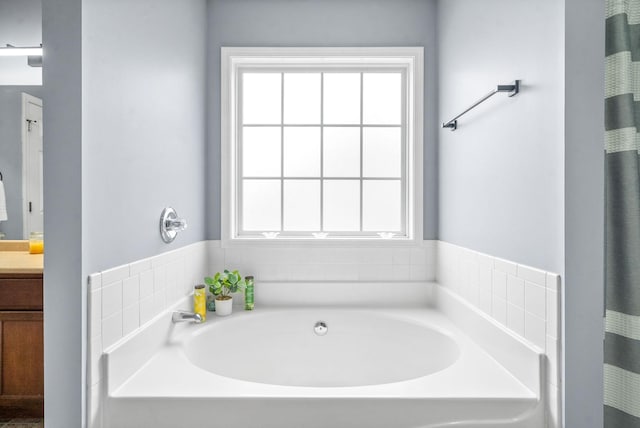 bathroom with vanity, a tub to relax in, and plenty of natural light