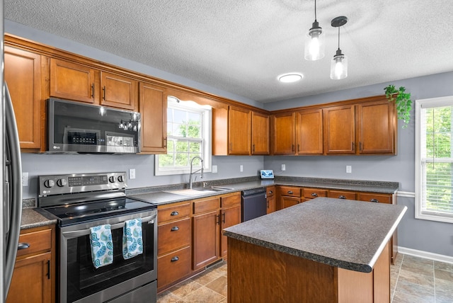 kitchen with stainless steel appliances, decorative light fixtures, a center island, and plenty of natural light