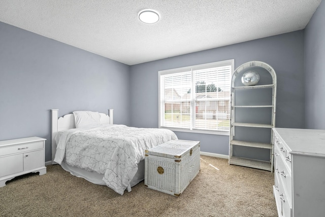 bedroom featuring a textured ceiling and light carpet