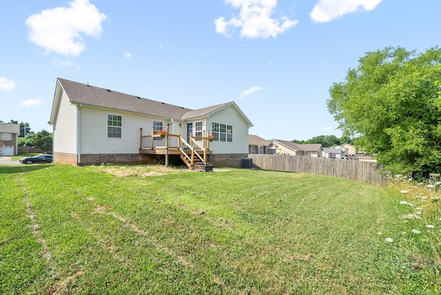 rear view of house featuring central AC, a lawn, and a wooden deck